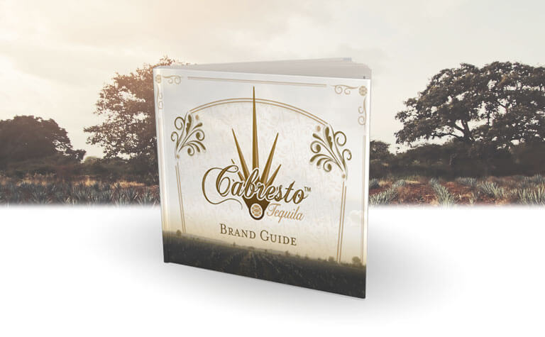 A Tequila Cabresto Brand Book in front of trees and crops