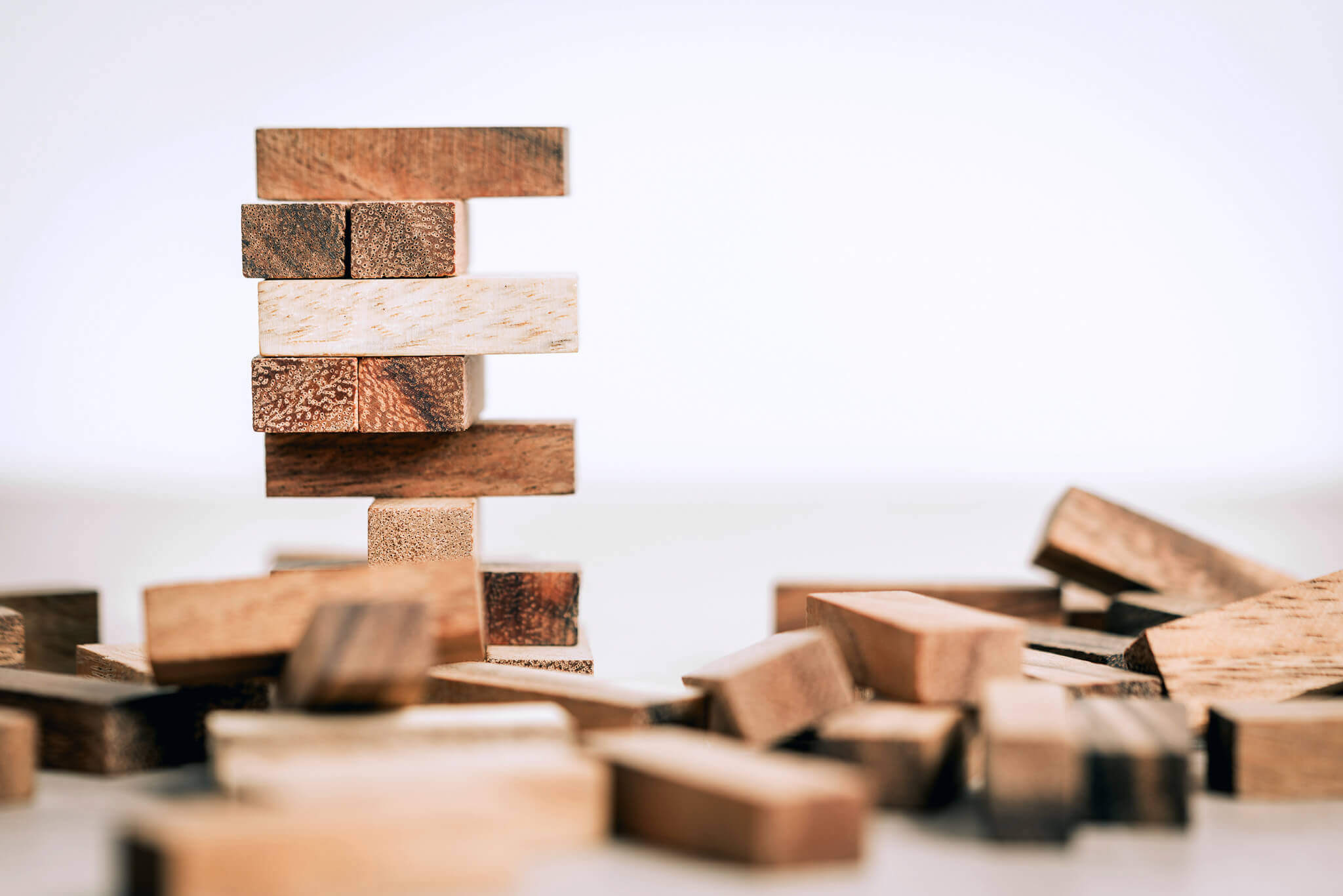 Wooden Jenga game blocks stacked to represent the importance and reliance of foundational marketing strategies